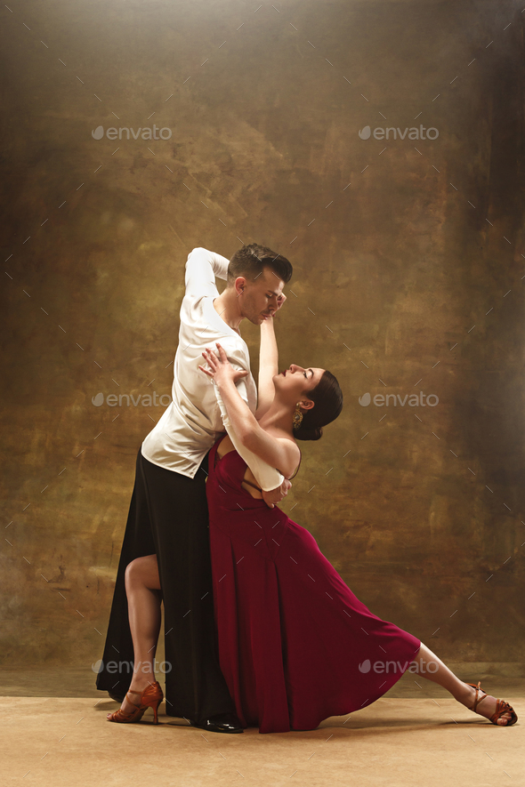 Dance ballroom couple in red dress dancing on studio background. Stock